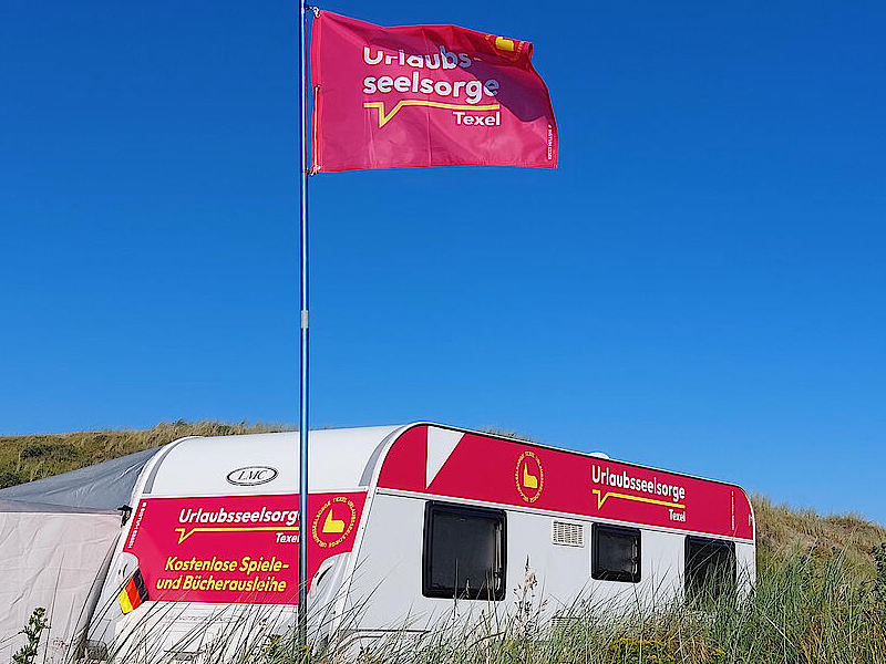 Der Wohnwagen der Urlaubsseelsorge steht in den Dünen auf Texel für die Feriengäste bereit. Foto: Stephan Hill / Bistum Essen Der Wohnwagen der Urlaubsseelsorge steht in den Dünen auf Texel für die Feriengäste bereit. Foto: Stephan Hill / Bistum Essen