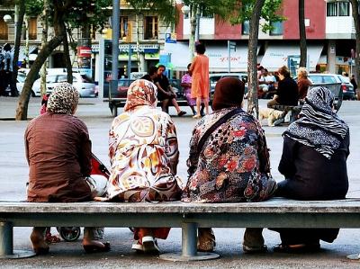 vier Frauen mit Kopftuch sitzen auf einer Bank