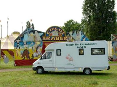 ein Fahrzeug der Schule für Zirkuskinder vor einem Zirkuszelt