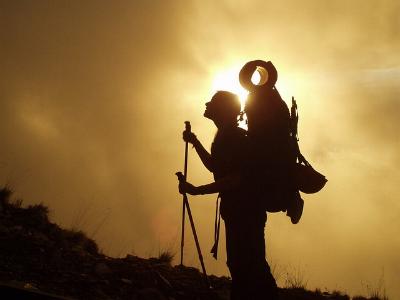 Pilger mit Rucksack im Sonnenuntergang