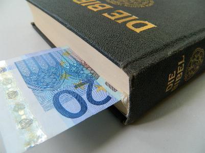 eine Bibel, in der ein 20-Euro-Schein steckt