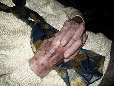 die über dem Bauch verschränkten Hände einer alten Frau