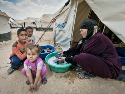 Frau mit Kindern vor einem Zelt im jordanischen Flüchtlingslager Zaatari