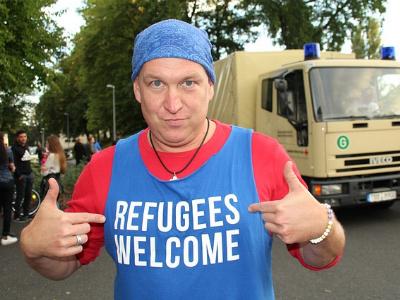 Mann mit blauem Shirt und Aufschrift 'Refugees wellcome'