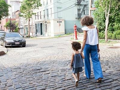 Mutter und Tochter laufen eine einsame Straße hinunter