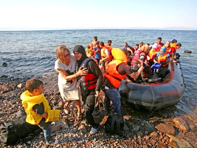 ein Schlauchboot mit Flüchtlingen kommt am Strand an