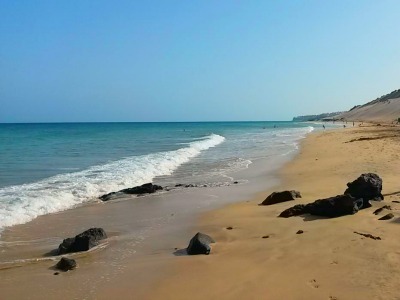 Sanfte Wellen treffen auf einen weitläufigen Sandstrand