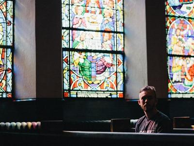 Mann sitzt alleine in einer Kirche