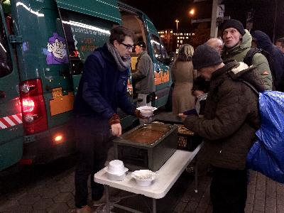 Helfer schenkt warme Suppe an Obdachlose aus