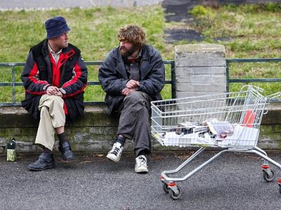 zwei Obdachlose sitzen auf einer Parkbank