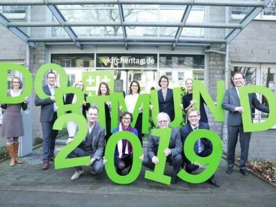 Menschen halten 'Dortmund 2019' in grünen Buchstaben in die Luft