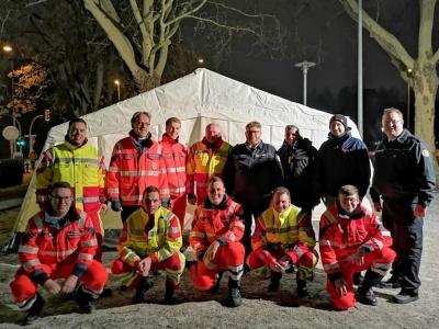 Helfer in Uniform vor einem Zelt