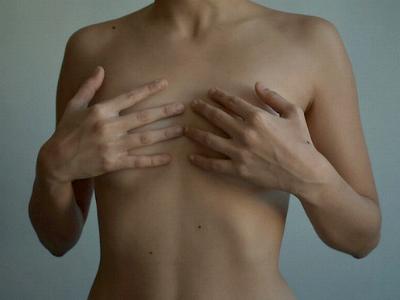 weibliche Brüste von Händen verdeckt