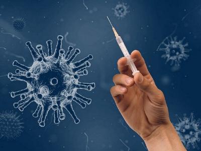 Hand mit Spritze kämpft gegen Corona-Viren