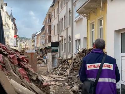 Ein Notfallseelsorger läuft durch eine von den Sturzfluten zerstörte Straße in Bad Neuenahr.