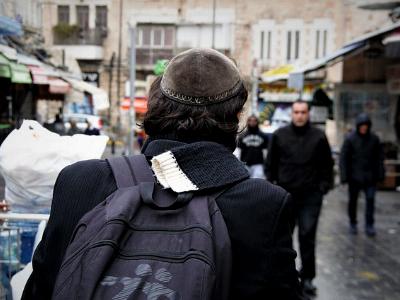 Mann mit jüdischer Kippa läuft durch eine Straße