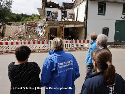 Helfer der Diakonie Katastrophenhilfe vor einem eingestürtzten Haus