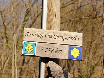 Holzschild mit Wegweiser auf einen Pilgerweg