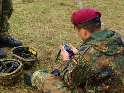 ein Bundeswehrsoldat schaut auf sein Handy