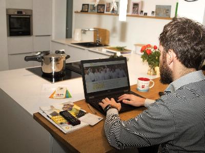 Mann mit Laptop am Küchentisch