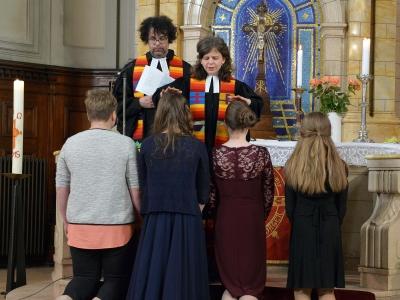 DRei Jugendliche werden bei ihrer Konfirmation am Altar gesegnet