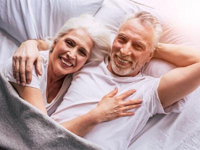 älteres Paar Arm in Arm im Bett