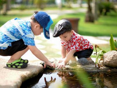 zwei kleine Kinder spiel an einem Bachlauf im Wasser