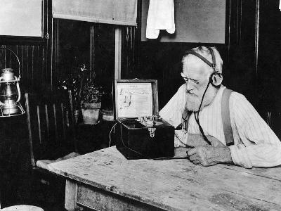 SW-Foto mit altem bärtigem Mann vor einem alten Radioempfänger