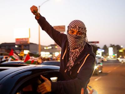 junger Mann versteckt sein Gesicht hinter enem Palästinenser-Tuch