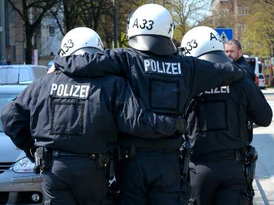 Ein verletzter Polizist wird von zwei Kollegen gestützt